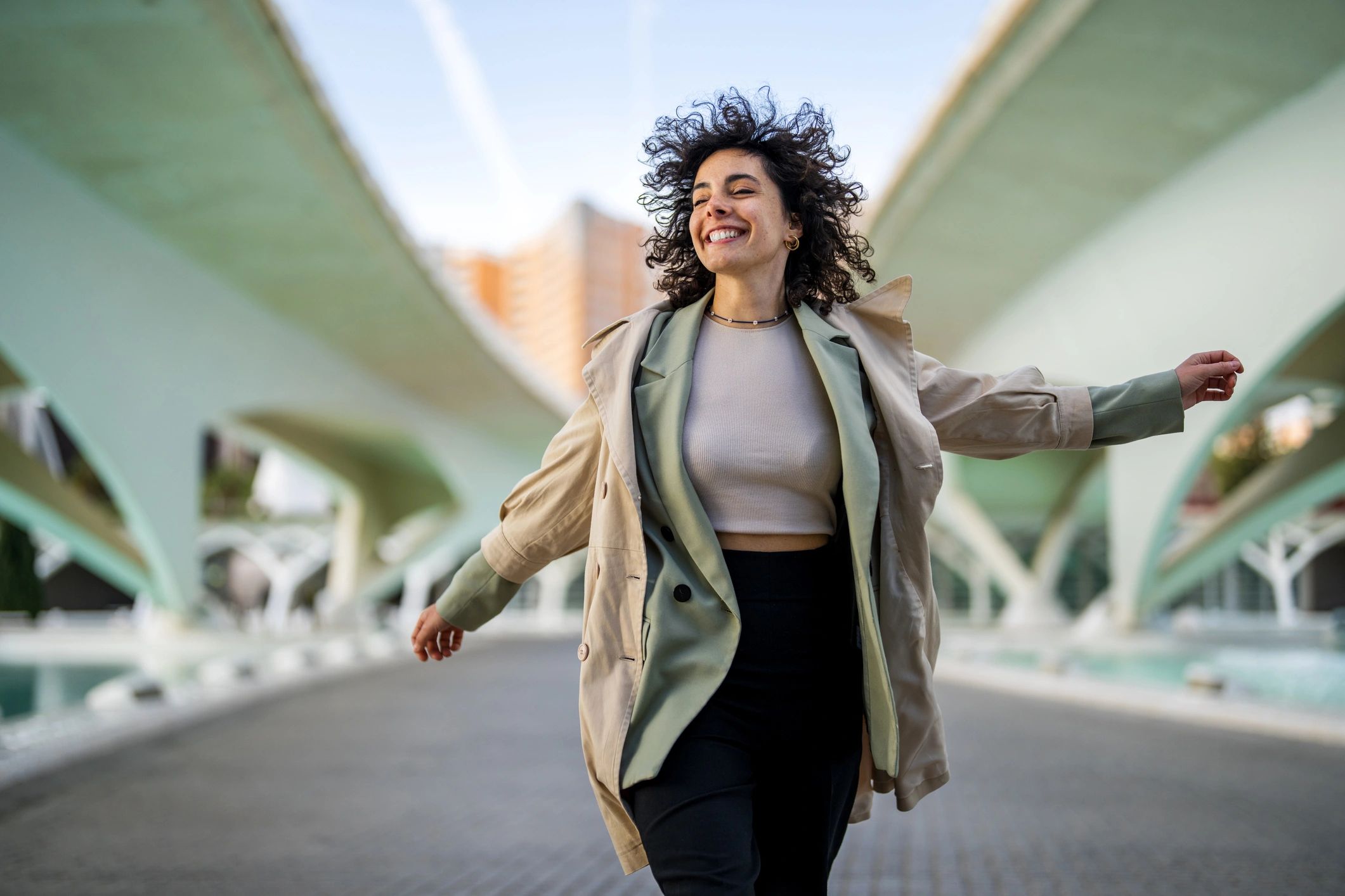Woman moving joyfully outdoors, celebrating a personal win