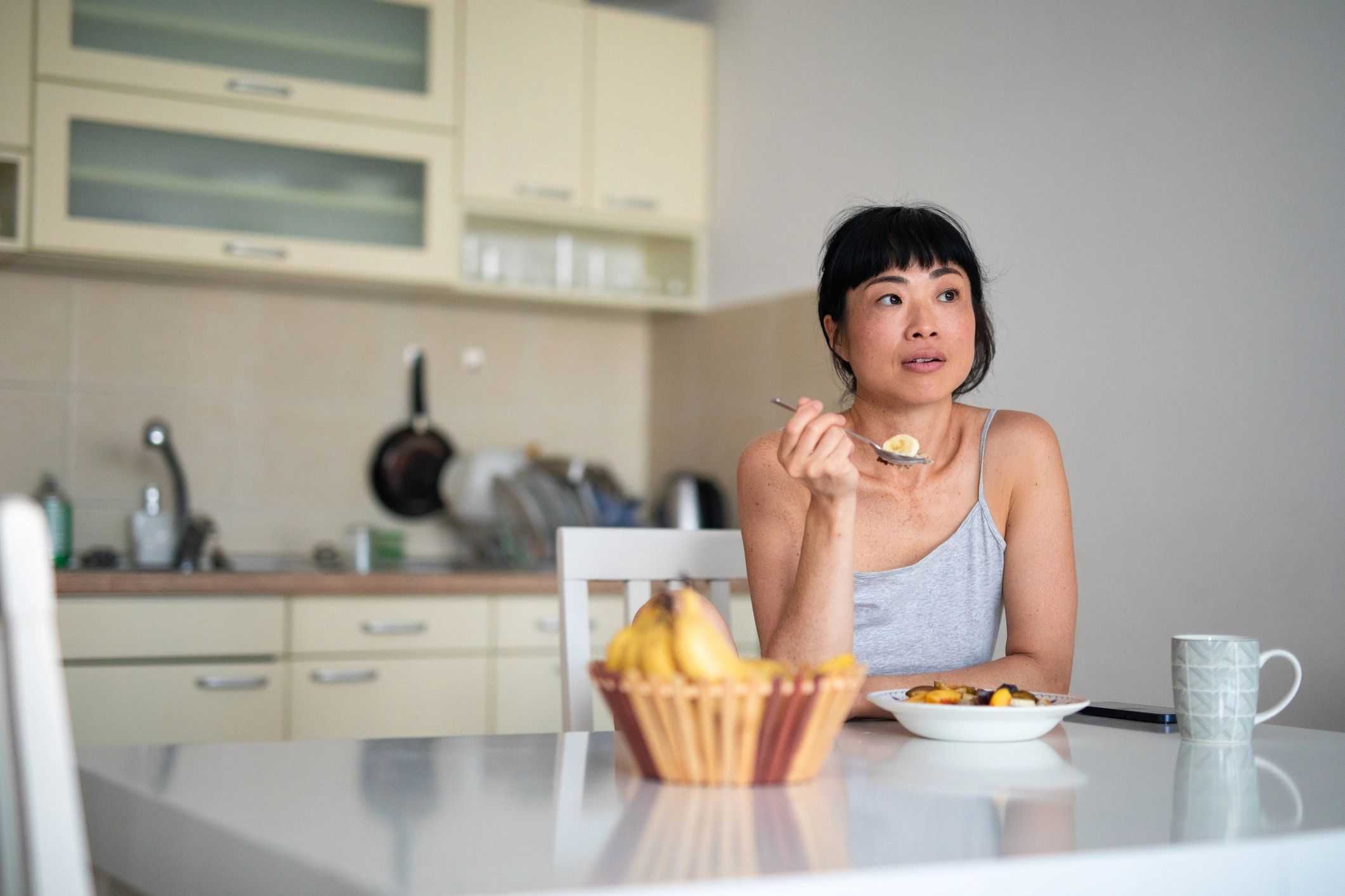 Woman enjoying a healthy breakfast at home, representing mindful nourishment